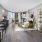 Spacious and well lit living room with wood flooring, large windows and open access to the kitchen
